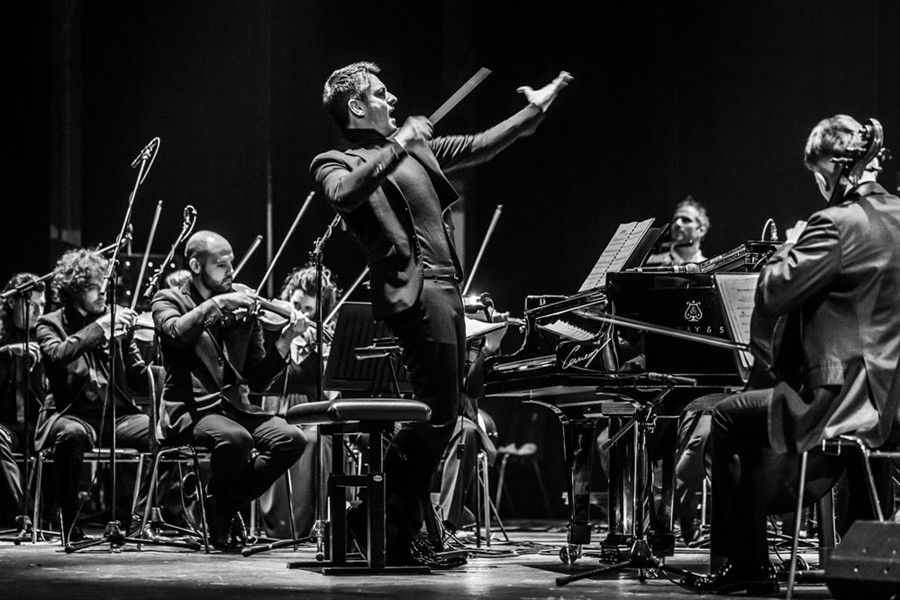 Maestro d'orchestra che dirige e artisti che suonano