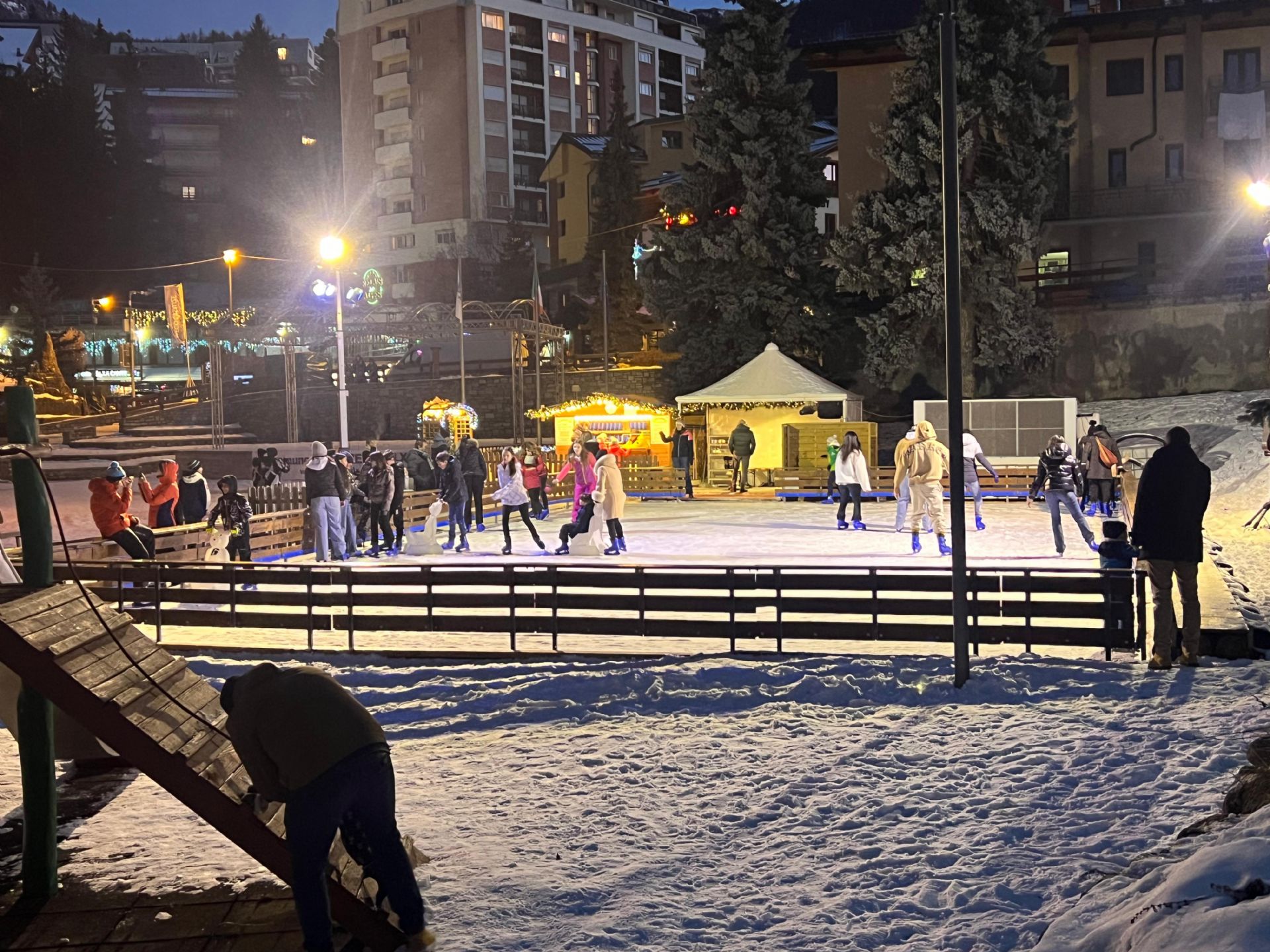 Immagine in notturna del pattinaggio su ghiaccio con pattinatori.