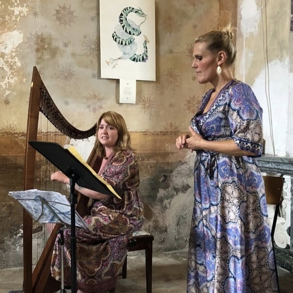 Due donne, una in piedi ed una seduta che suona l'arpa