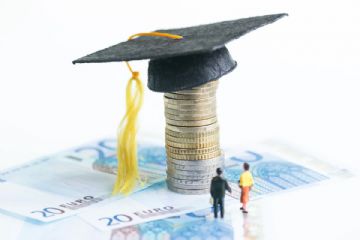 Si visualizza il copricapo tipico indossato dai neolaureati, caratterizzato dalla forma quadrata e piatta con una nappa pendente, chiamato tocco, poggiante su una pila di monete e banconote in euro e due uomini in miniatura intenti ad osservare la colonna di monete sormontate dal cappello.