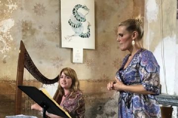 Due donne, una in piedi ed una seduta che suona l'arpa